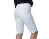 Woman wearing a navy sweater and white shorts on a plain background