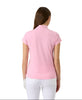 Woman wearing a pink polo shirt on a light gray background