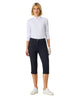 Woman wearing a white polo shirt and navy capri pants on a white background