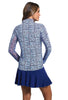 Woman wearing a patterned long-sleeve top and blue skirt on a white background