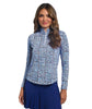 Woman wearing a blue patterned long-sleeve top and blue skirt on a white background