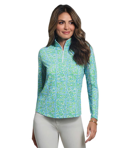 Woman wearing a light blue floral patterned long-sleeve top and white pants on a white background