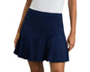 Person wearing a navy blue skirt and white sneakers on a gray background