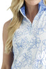Woman wearing a sleeveless floral blouse with blue and white pattern on a plain background