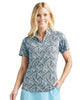 Woman wearing a patterned shirt and light blue skirt on a white background
