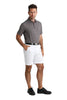 Man wearing a patterned polo shirt, white shorts, and black shoes on a white background