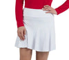 Woman wearing a red sweater and white skirt on a plain background