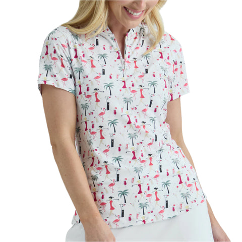 Woman wearing a patterned shirt with flamingos and palm trees on a plain background