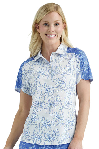 Woman wearing a white floral patterned polo shirt with blue accents on a plain background