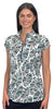 A woman modeling a short-sleeve collared top with a white base and a teal and black tropical leaf pattern, set against a solid light gray background.