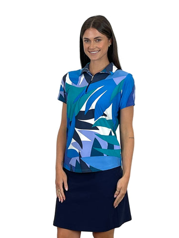 Woman wearing a blue and green patterned shirt with a navy skirt on a white background