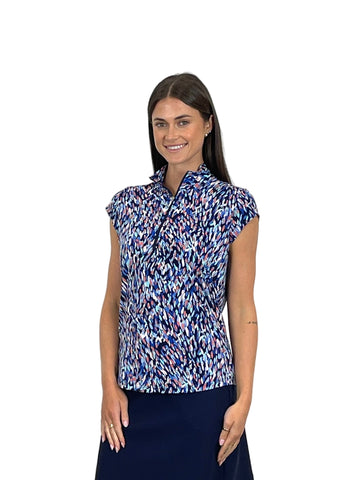 Woman wearing a patterned blue and white blouse against a white background