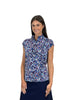 Woman wearing a patterned blue and white blouse against a white background