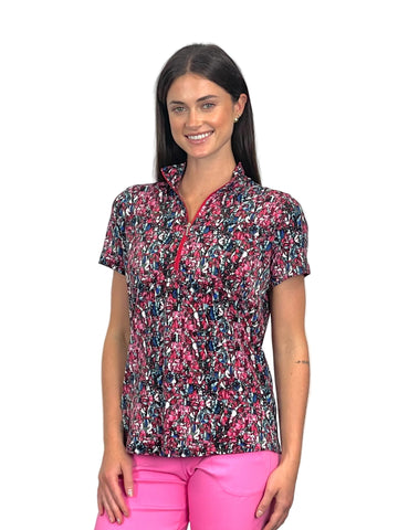 Woman wearing a colorful patterned shirt and pink pants on a white background