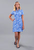 Woman wearing a blue floral dress on a gray background