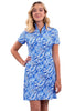 A woman modeling a short-sleeve collared dress with a blue and white abstract floral pattern, standing against a solid studio background.
