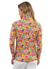 Woman wearing a colorful patterned shirt and white shorts on a white background