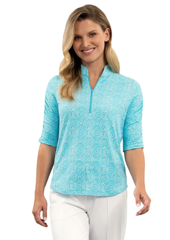 Woman wearing a light blue patterned shirt and white pants on a white background