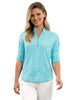 Woman wearing a light blue patterned shirt and white pants on a white background