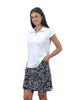 Woman wearing a white polo shirt and black and white checkered skirt on a white background