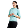 Woman wearing a light blue athletic top with a quarter zip on a white background