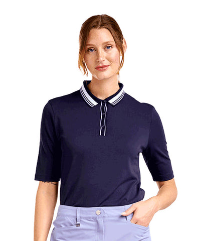 Woman wearing a navy blue polo shirt with white trim on a white background