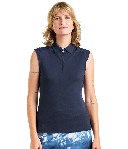 Woman wearing a navy sleeveless polo shirt with a white background