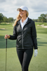 Woman golfer wearing Sporte Leisure black packable wind jacket on a golf course
