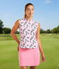 Woman in a pink patterned sleeveless top and pink skirt on a golf course